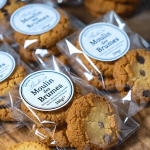 Pile de biscuits artisanaux sablés aux pépites de chocolat noir sur une table en bois.