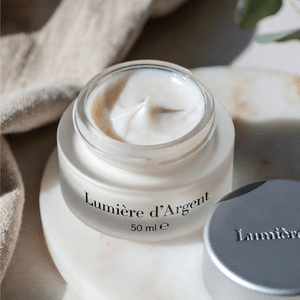 Pot de crème hydratante visage ouverte avec texture onctueuse blanche.